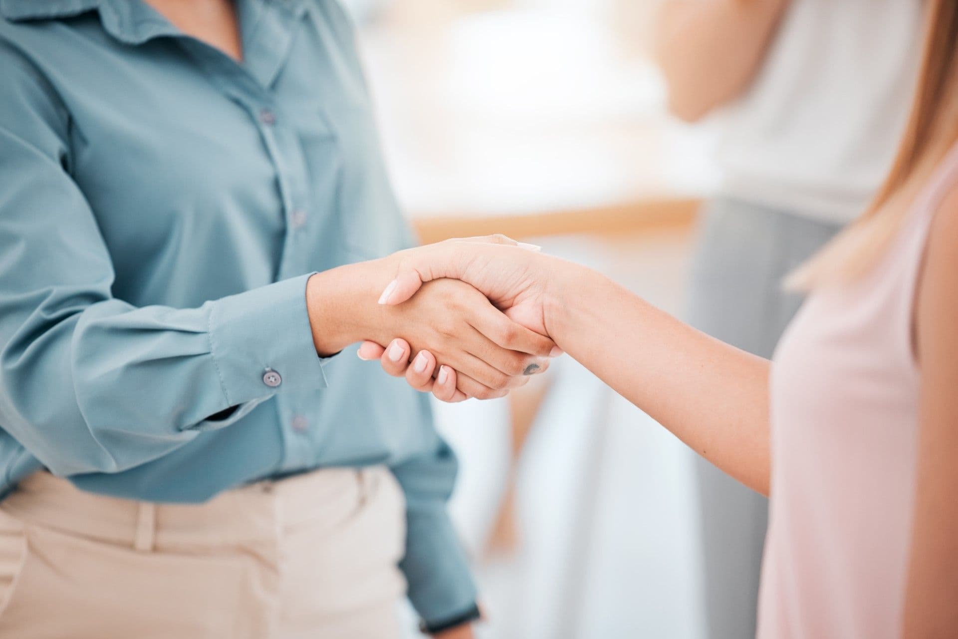 Two professionals shaking hands in a business meeting or agreement